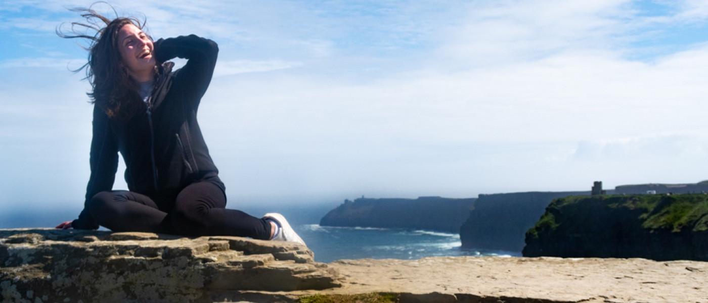 一个学生坐在海边俯瞰爱尔兰的悬崖